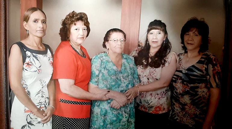 Doña Pola al centro, tomada de las manos de sus cuatro hijas