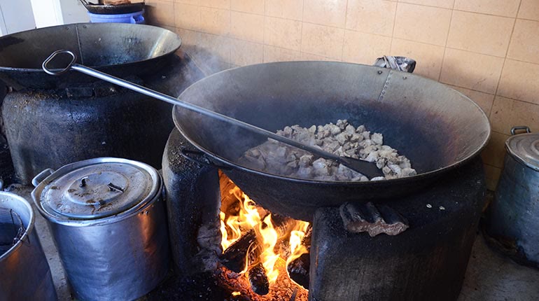 Peroles gigantes sobre un fogón de leña encendido, en una cocina chicharronera del valle